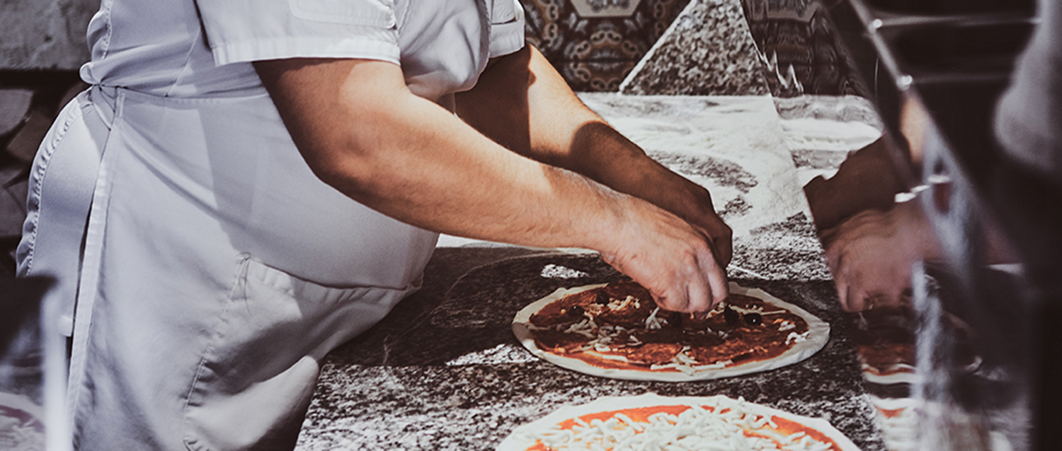 Chef is making pizza at the restaurant kitchen